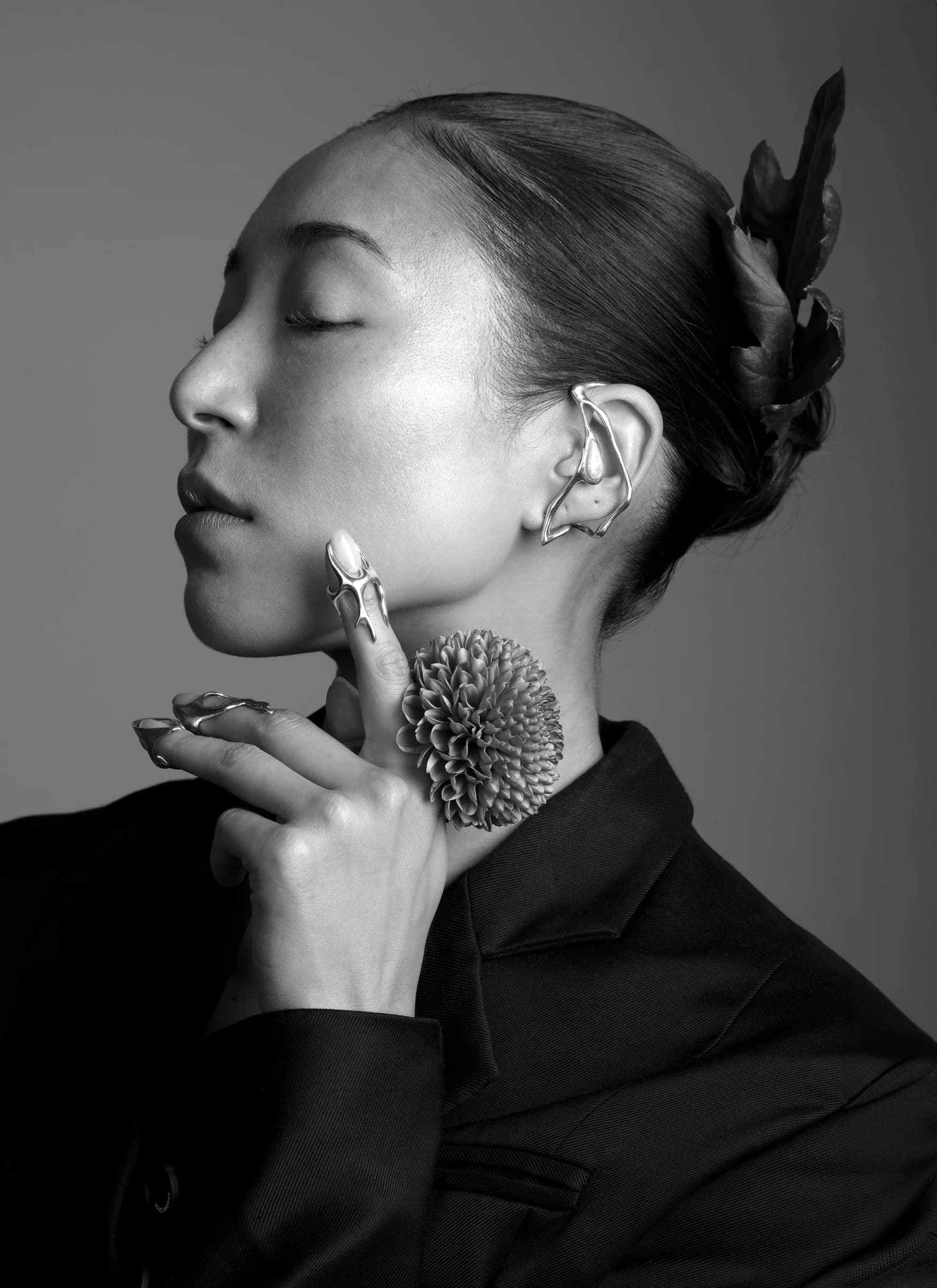 Black-and-white profile with an earring and ring for Binadi